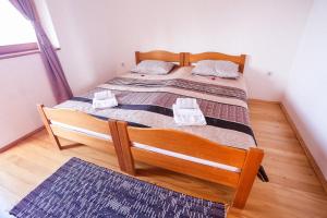 a bedroom with a wooden bed with two pillows on it at Vikendica Kristina in Prijedor