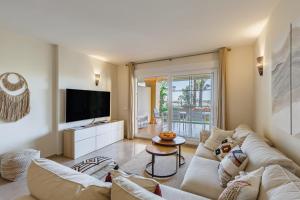 sala de estar con sofá y TV en Cumbres del Rodeo, en Marbella