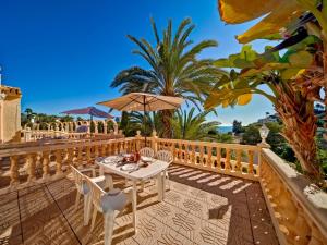 una mesa con sillas y una sombrilla en el patio en Apartment Canuta Baja 3 by Interhome, en Calpe