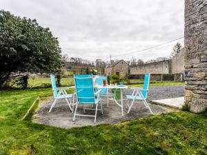 a table and chairs in the yard of a house at Holiday Home Le Clos Renard by Interhome in Commes