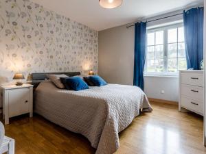 a bedroom with a bed with blue pillows on it at Holiday Home Le Clos Renard - COM401 by Interhome in Commes