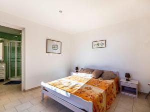 a bedroom with a bed with an orange blanket at Apartment La Petite Toscane - CBX100 by Interhome in Cabris