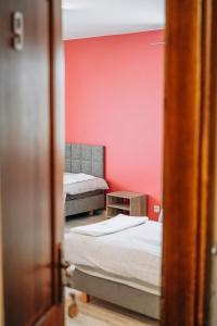 Habitación con 2 camas y pared roja. en Redwood Hostel en Lublin