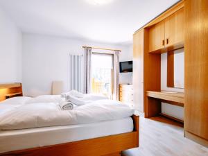 a bedroom with a large white bed and a window at Apartment Carmen-4 by Interhome in Soraga +27 photos