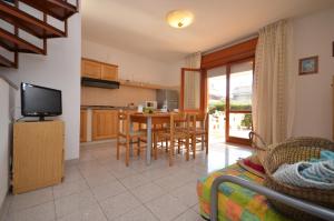 a kitchen and living room with a table and chairs at Villaggio Selene in Bibione