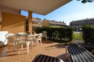 a patio with a table and chairs on a patio at Villaggio Selene in Bibione