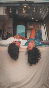 two people laying on a bed in a van at Geo Campers - Full time living camper rental in Kutaisi, Tbilisi, Batumi, Georgia in Kutaisi