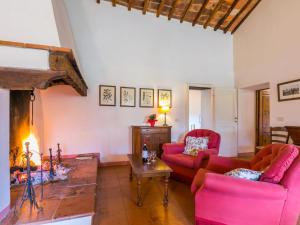 un soggiorno con 2 sedie rosse e un camino di Holiday Home Il Laghetto by Interhome a Pergine Valdarno