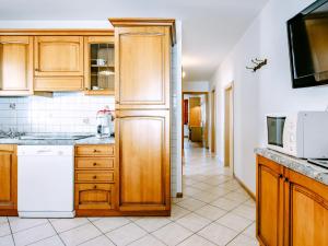 una cucina con armadietti in legno ed elettrodomestici bianchi di Apartment Valentini by Interhome a Mazzin