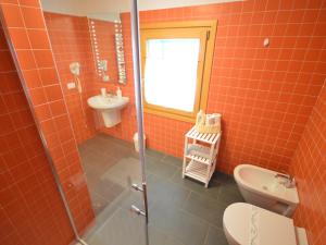 un bagno piastrellato arancione con servizi igienici e lavandino di Apartment Cjase Fravins-4 by Interhome a Raveo