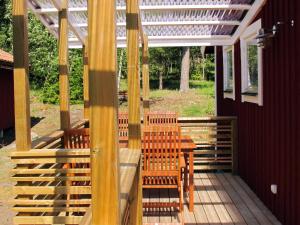 a patio with a table and chairs and a pergola at Chalet Lindby Karneolen - STH151 by Interhome in Adelsö