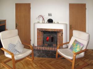 un soggiorno con 2 sedie e un camino di Chalet Lindby Karneolen - STH151 by Interhome ad Adelsö