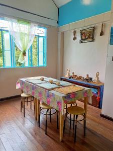 una sala da pranzo con tavolo, sedie e finestra di Banaue Transient House Bed and Breakfast a Banaue