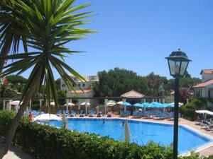 a swimming pool with a palm tree and a light pole at Old Village in Vilamoura