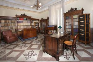 a library with antique furniture and a desk and a chair at Historical Suites VVM in Lecce
