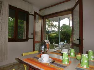 uma mesa de jantar com uma chaleira de chá em Three-Bedroom Villa with garden, parking and ac em Bibione