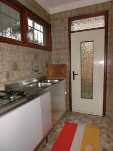 a kitchen with a sink and a door at Three-Bedroom Villa with garden, parking and ac in Bibione
