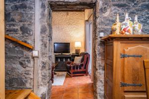 einen Flur mit einem Wohnzimmer mit einer Steinmauer in der Unterkunft King Shelter by Homie in Lanceiros