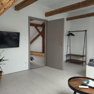 ein Wohnzimmer mit einer Schiebetür und einem TV in der Unterkunft Apartmány s výhledem na zámek II in Vimperk