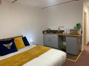 ein Schlafzimmer mit einem Bett und eine Küche mit einer Theke in der Unterkunft Premium Inn Apartments in Methley