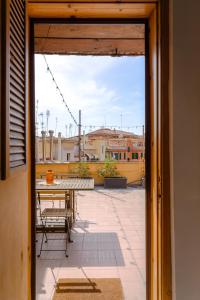 Aussicht von einer Tür auf eine Terrasse mit einem Tisch in der Unterkunft La mansarda del Papa - Zen Real Estate in Rom