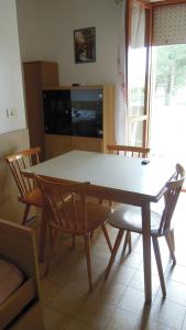 a table and chairs in a living room with a television at Nice apartment in a residence with swimming pool in Bibione +31 photos