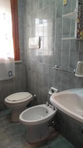 a bathroom with a toilet and a sink at Nice apartment in a residence with swimming pool in Bibione