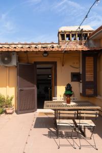 eine Terrasse mit einem Tisch und Stühlen vor einem Haus in der Unterkunft La mansarda del Papa - Zen Real Estate in Rom