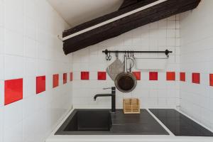 eine Küche mit einem Waschbecken und einer Pfanne an der Wand in der Unterkunft La mansarda del Papa - Zen Real Estate in Rom
