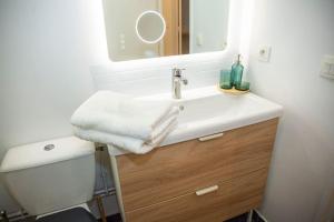 a bathroom with a white sink and a mirror at Grand 2 pièces balcon Parking porte PARIS in Aubervilliers