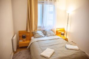 a bedroom with a large bed with a window at Grand 2 pièces balcon Parking porte PARIS in Aubervilliers