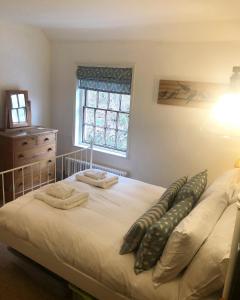 a bedroom with a bed with two pillows and a window at Rock View Cottage, 2 bedrooms near Alton Towers in Alton