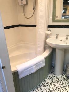 a bathroom with a bath tub and a sink at Rock View Cottage, 2 bedrooms near Alton Towers in Alton