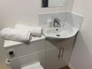 Baño blanco con lavabo y aseo en Premium Inn Apartments, en Methley