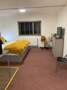 a bedroom with a bed with a yellow blanket on it at Premium Inn Apartments in Methley