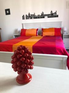 1 dormitorio con 2 camas y un jarrón de bolas rojas en Cosmopolitan B&B, en Palermo