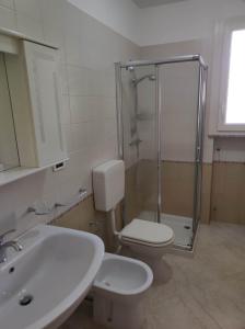 een badkamer met een douche, een toilet en een wastafel bij Sea urchin holiday home in Leuca