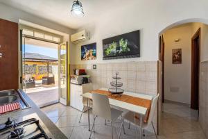 kuchnia i jadalnia ze stołem i krzesłami w obiekcie Casa Flavia w mieście Nebida