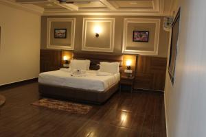 a bedroom with a large bed in a room with wooden floors at Flamingo Club and Resort Una 3 Km Away from Diu Check Post in Diu