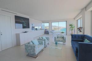 een woonkamer met 2 blauwe stoelen en een aanrecht bij LA MER Breathtaking sea view luxurious design apartment in Cannes
