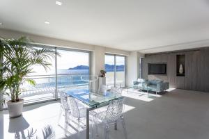 een woonkamer met een glazen tafel en stoelen bij LA MER Breathtaking sea view luxurious design apartment in Cannes