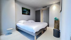 een slaapkamer met een groot bed met witte lakens bij LA MER Breathtaking sea view luxurious design apartment in Cannes