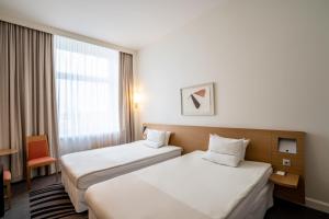 Postel nebo postele na pokoji v ubytování Novotel Vilnius Centre
