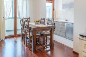 Una cocina con una mesa y sillas de madera. en APARTMAN LARA, en Žabljak
