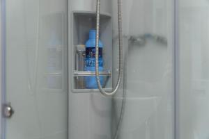 una puerta de ducha con una botella de agua. en APARTMAN LARA, en Žabljak