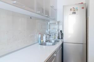 Una cocina blanca con fregadero y refrigerador. en APARTMAN LARA, en Žabljak 21 fotos más