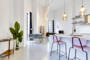 uma sala de estar com cadeiras cor-de-rosa e uma cozinha em Hotel Watertoren West em Groningen