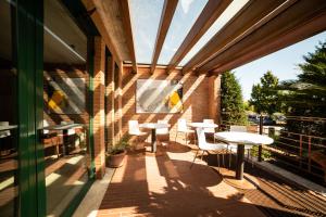 un patio con mesas y sillas en un edificio en HOTEL QUERINI Budget & Business Hotel Sandrigo, en Sandrigo