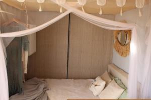 a bedroom with a bed with a mosquito net at Micro House (Back to Nature) in La Oliva