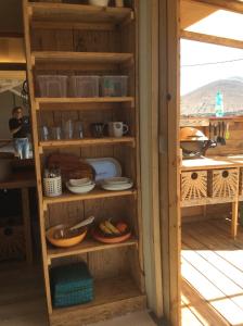 a wooden shelf with plates and bowls on it at Micro House (Back to Nature) in La Oliva